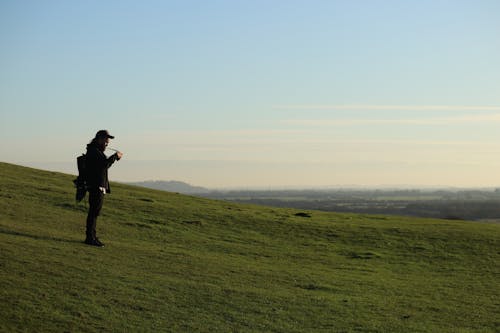 A Man Standing on a Green Grass Field