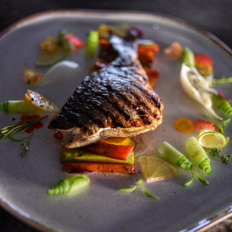 Grilled Fish With Fresh Herbs On A Ceramic Plate