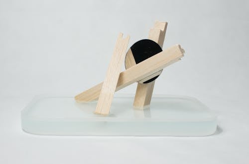 Wooden artwork on glass stand in studio
