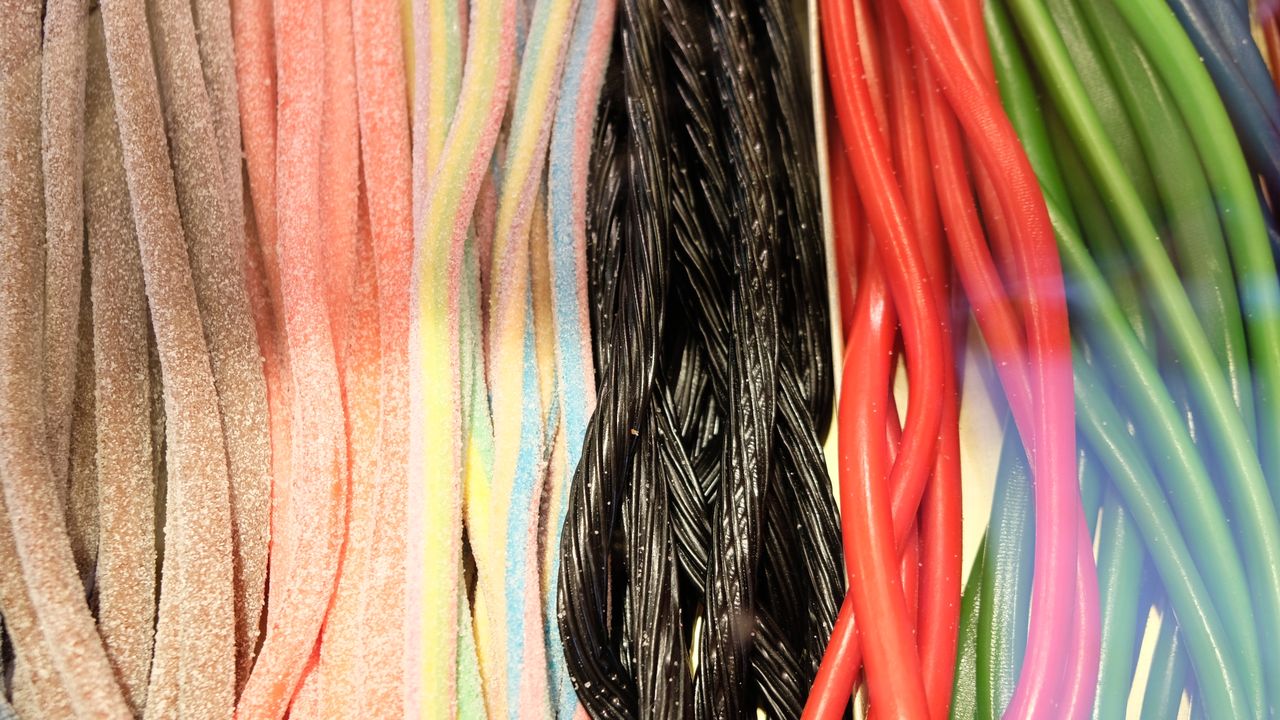 multicolored sweet marmalade gummy sticks with sugar powder placed in