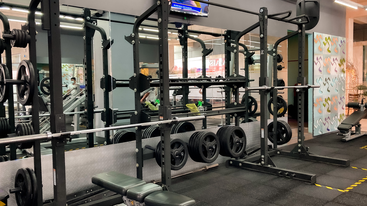 A spacious gym featuring benches, weights, and exercise machines for varied workouts.