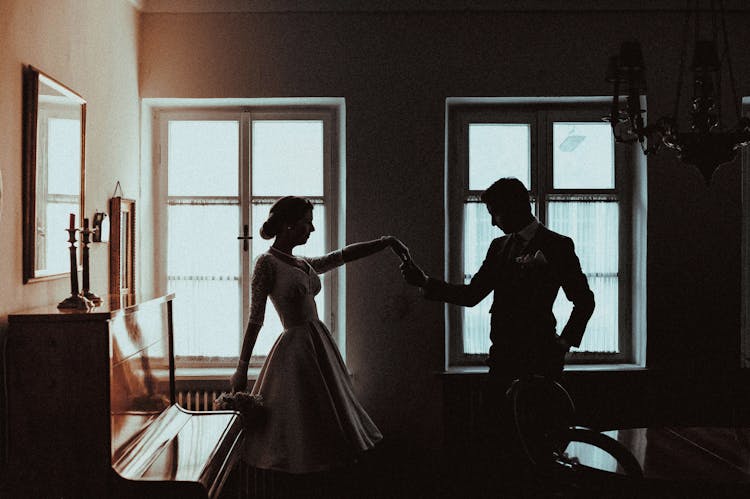 Silhouette Of A Couple Standing By The Window