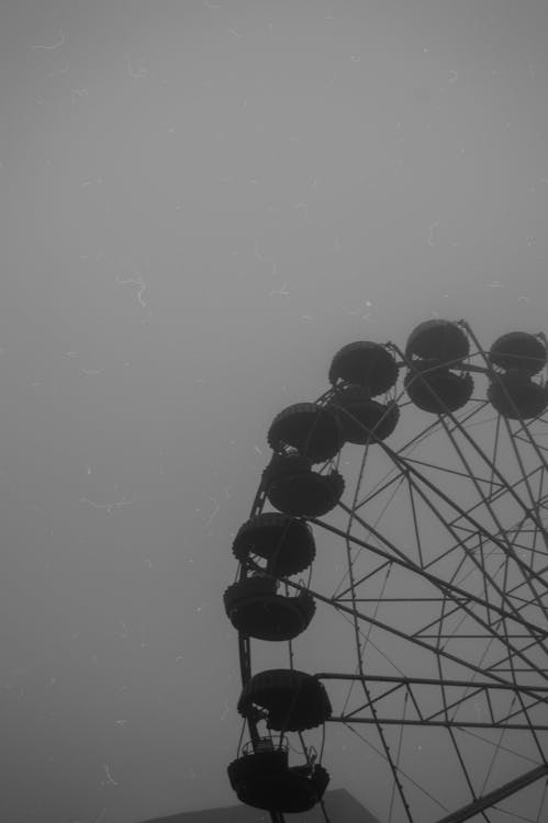 Grayscale Photo of a Ferris Wheel under Gray Clouds