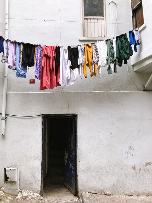 Free Vibrant clothes hanging on a line in an urban alley, showcasing everyday life. Stock Photo