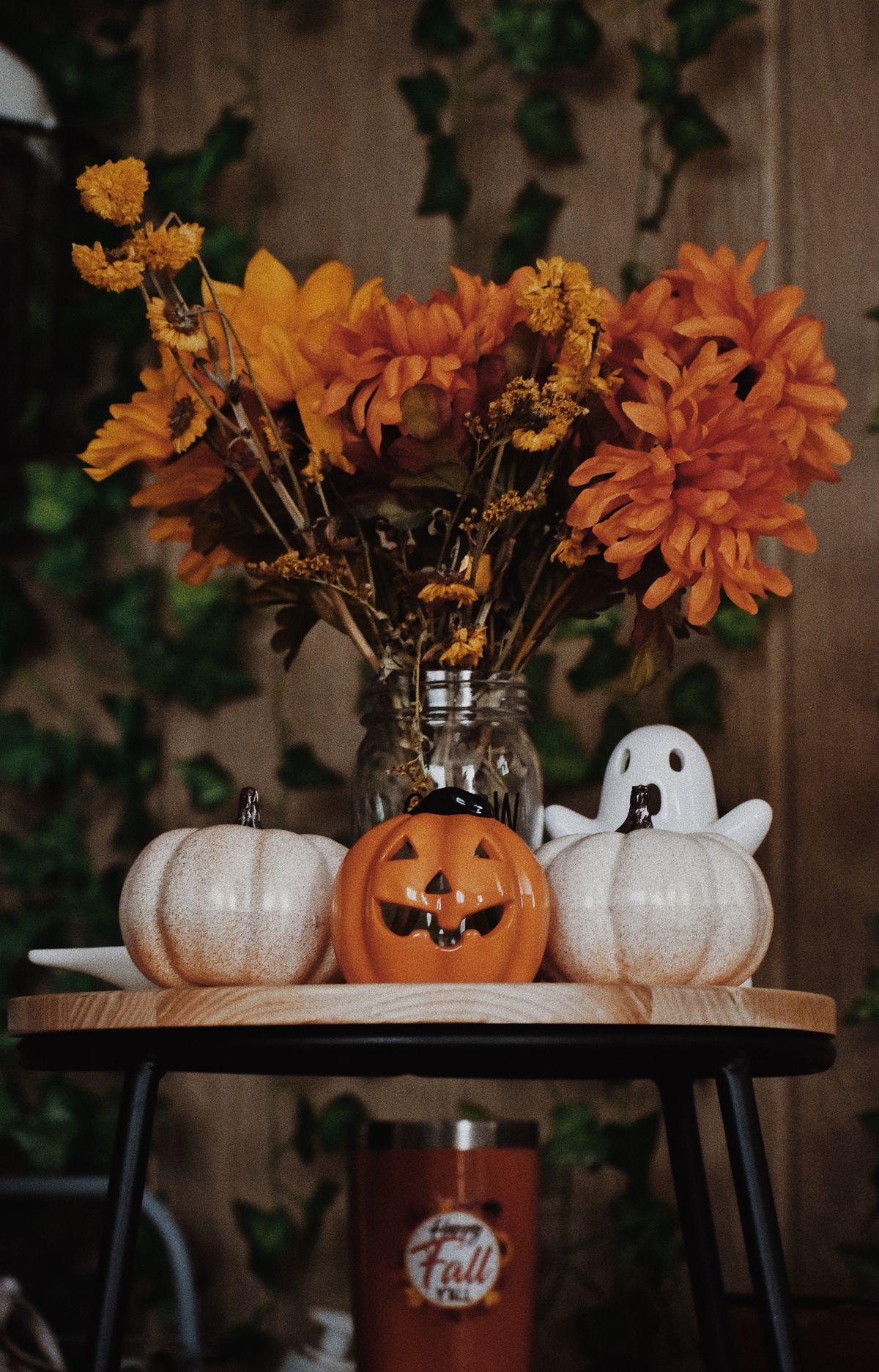 Cozy Halloween arrangement with pumpkins, orange flowers, and festive decor