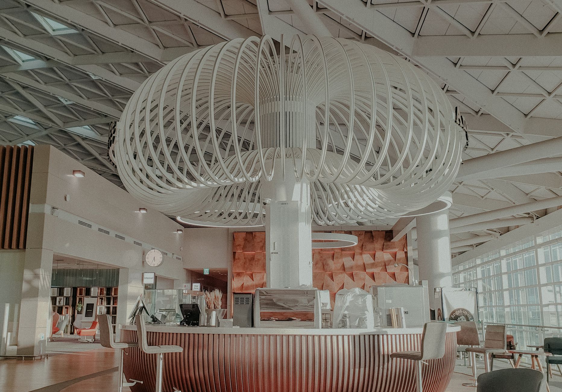 Discover the modern architectural design of a stylish cafe with unique lighting structure inside a spacious building.