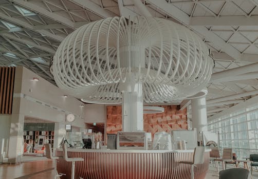 Discover the modern architectural design of a stylish cafe with unique lighting structure inside a spacious building.