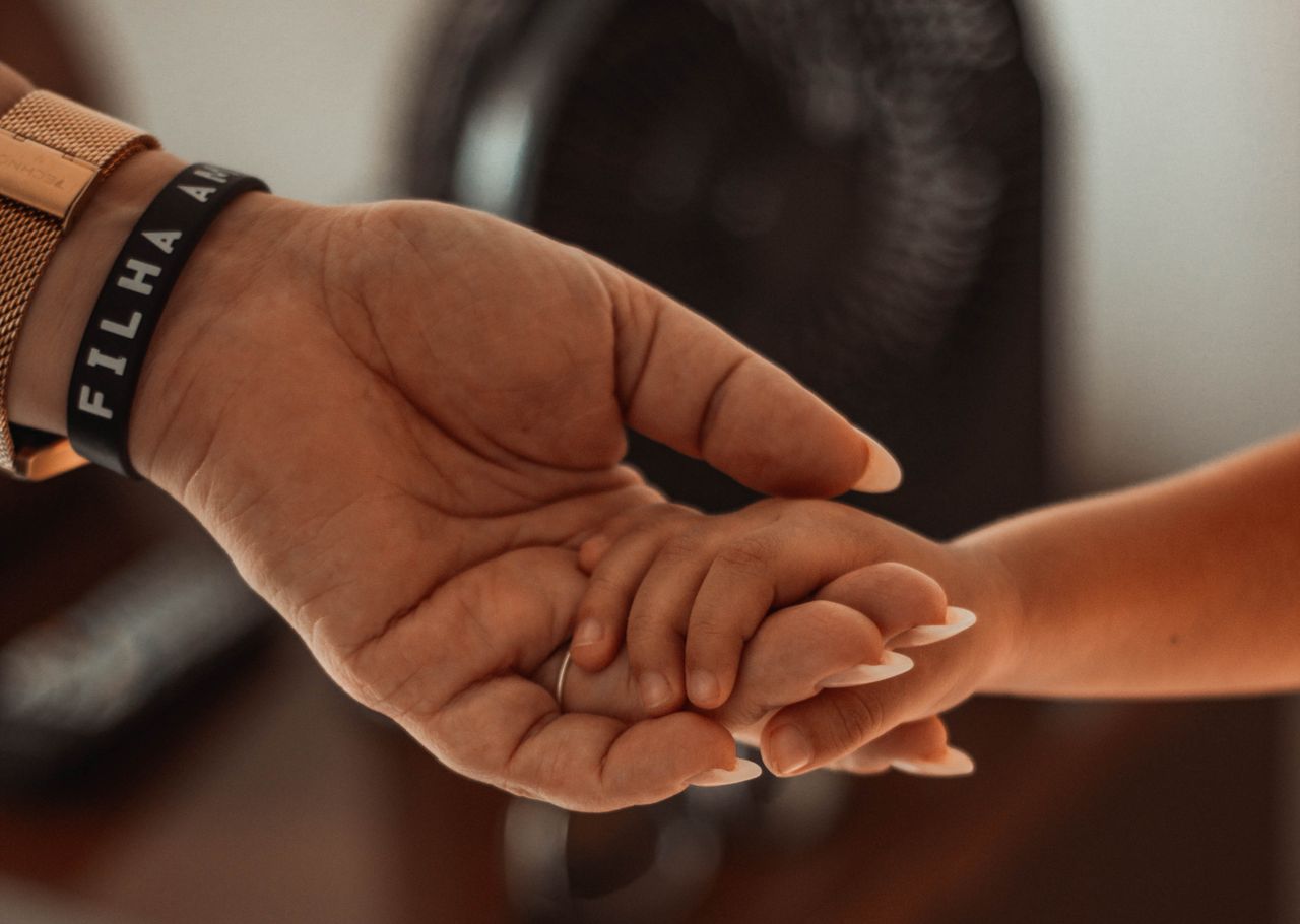 emotional close up of a parent and child holding hands showing connect