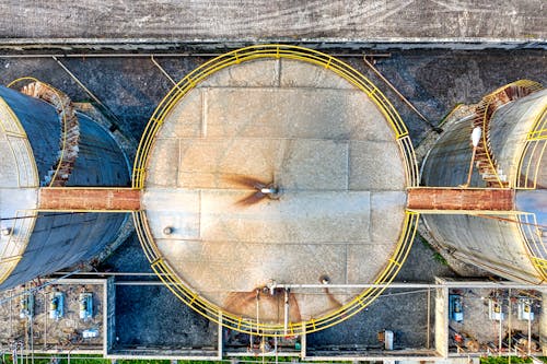 Top view of huge industrial tanks connected with rusty passages located at territory of factory