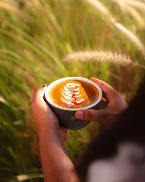 Free Close-Up Shot of a Person Holding a Cup of Cappuccino Stock Photo