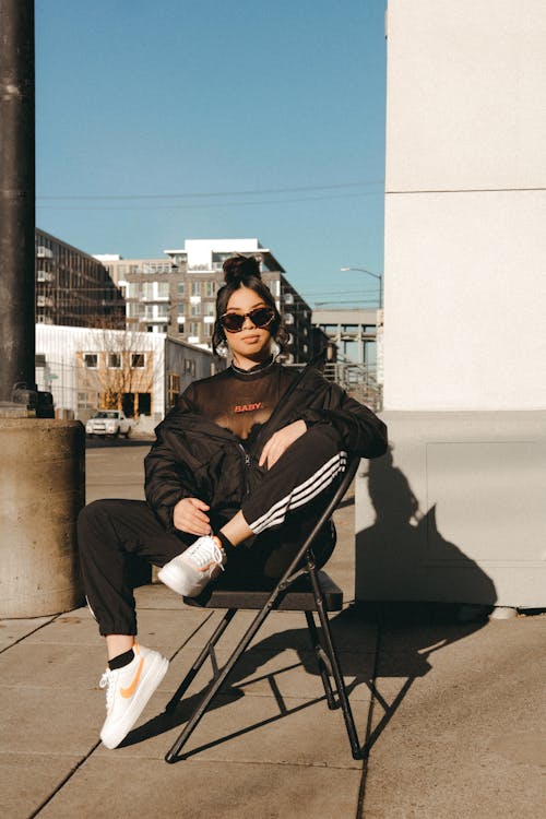 Free Confident young ethnic female chilling on street on sunny day Stock Photo