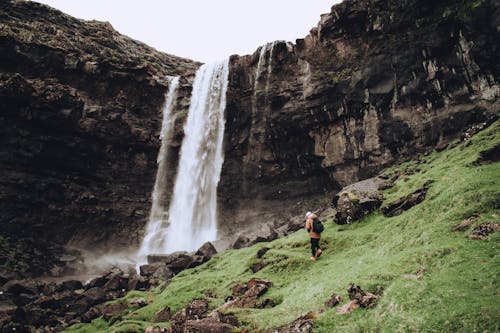 Free Person Wearing Black Backpack Standing Near the Waterfalls Stock Photo