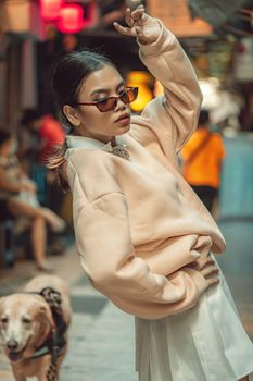 Stylish woman poses in Manila street with dog, capturing urban fashion vibe.