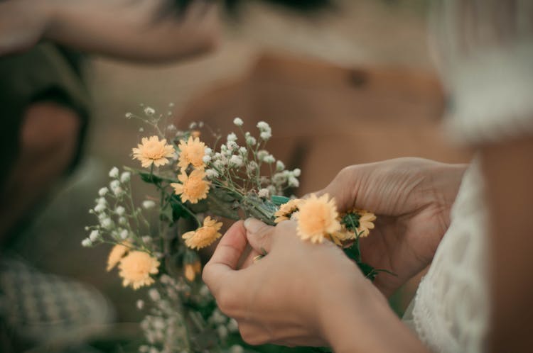 Person Holding White And Orange Flowers