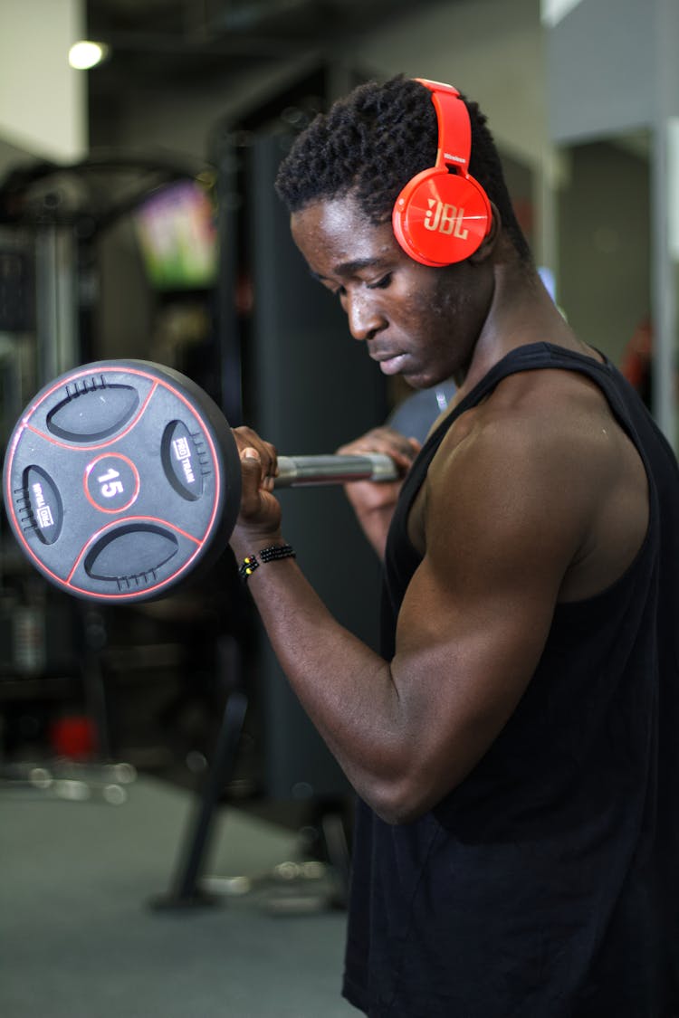 Man In Black Tank Top Carrying A Barbell