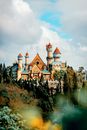 Bright castle facade against coniferous trees under cloudy sky in amusement park of Batangas Philippines in daylight