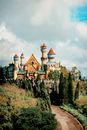 Roadway and trees against castle exterior with decoration under cloudy sky in Batangas Philippines in daytime