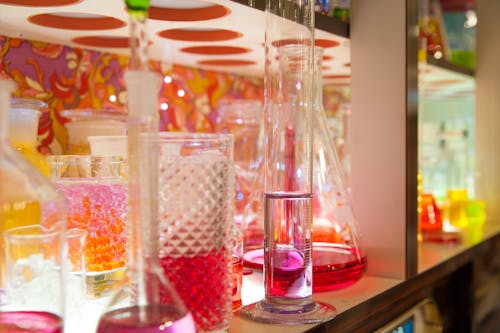 Assorted Laboratory Instruments on Shelf Filled With Liquids