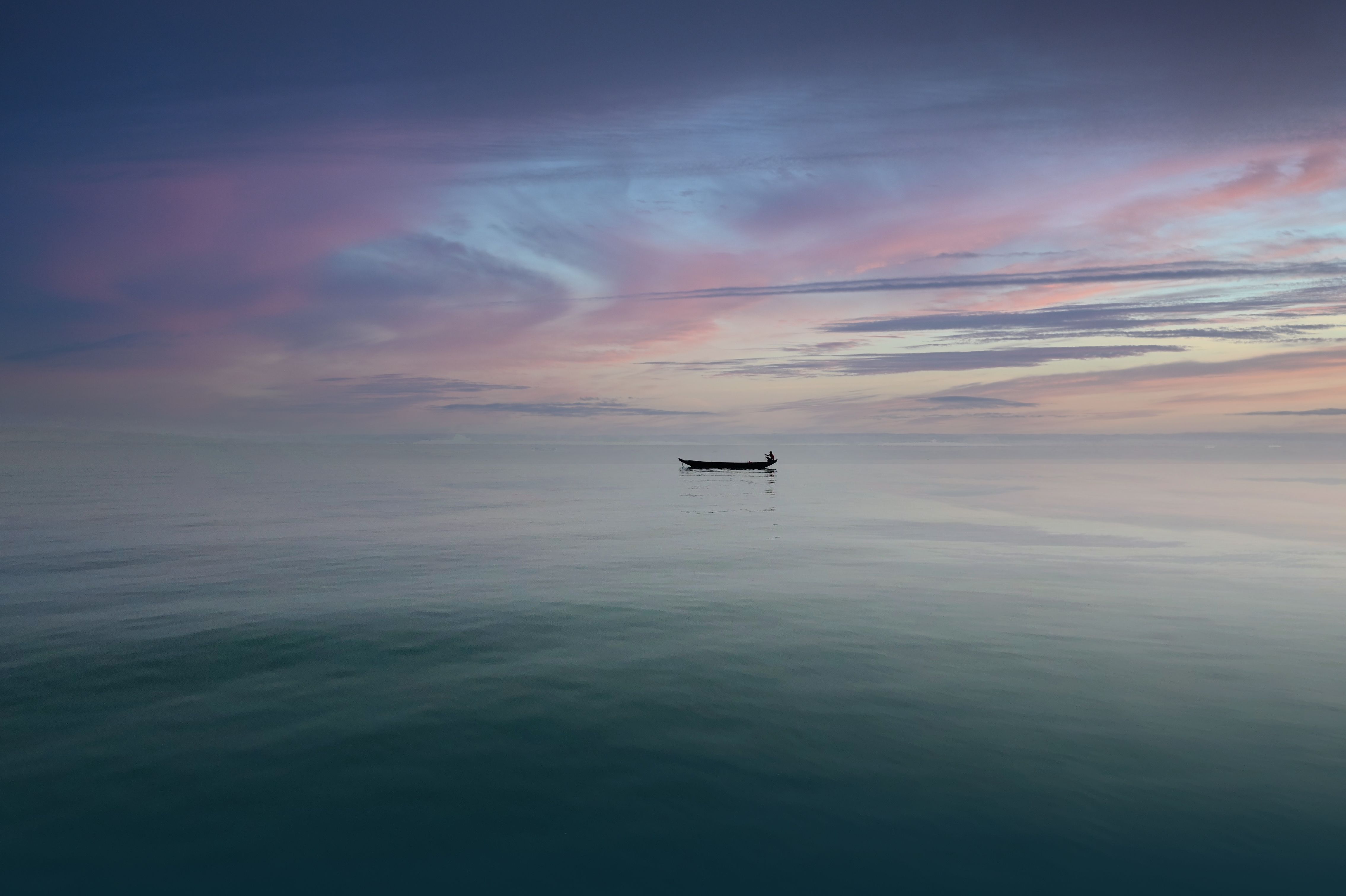 Silhouette of a boat on the ocean during sunset