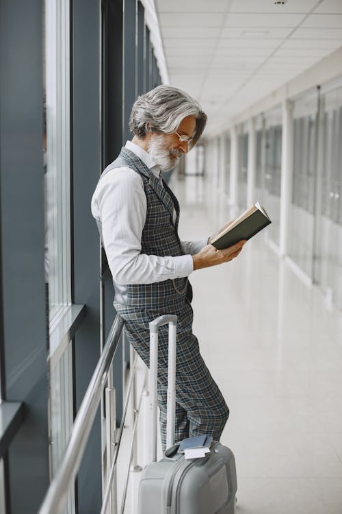 Man in Checked Outfit Reading a Book