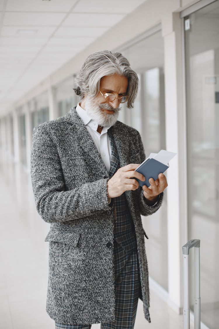 Photo Of A Man With Gray Hair Looking At His Passport