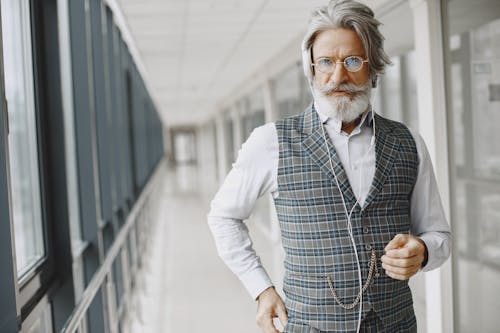 Man in Checkered Vest Standing on the Hallway