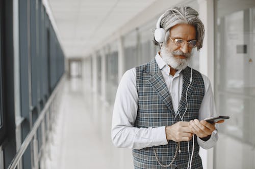 Man in Blue and White Plaid Vest Wearing White Headphones
