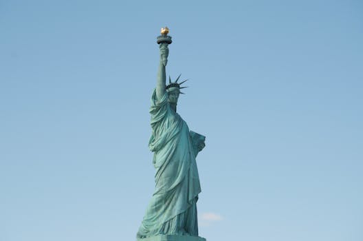 Iconic Statue of Liberty under a blue sky, showcasing its grandeur as a symbol of freedom.