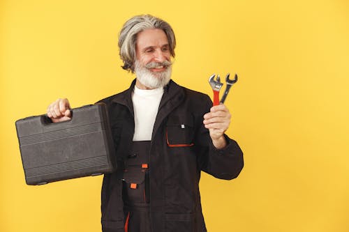 Free Man Smiling While Holding Wrenches Stock Photo