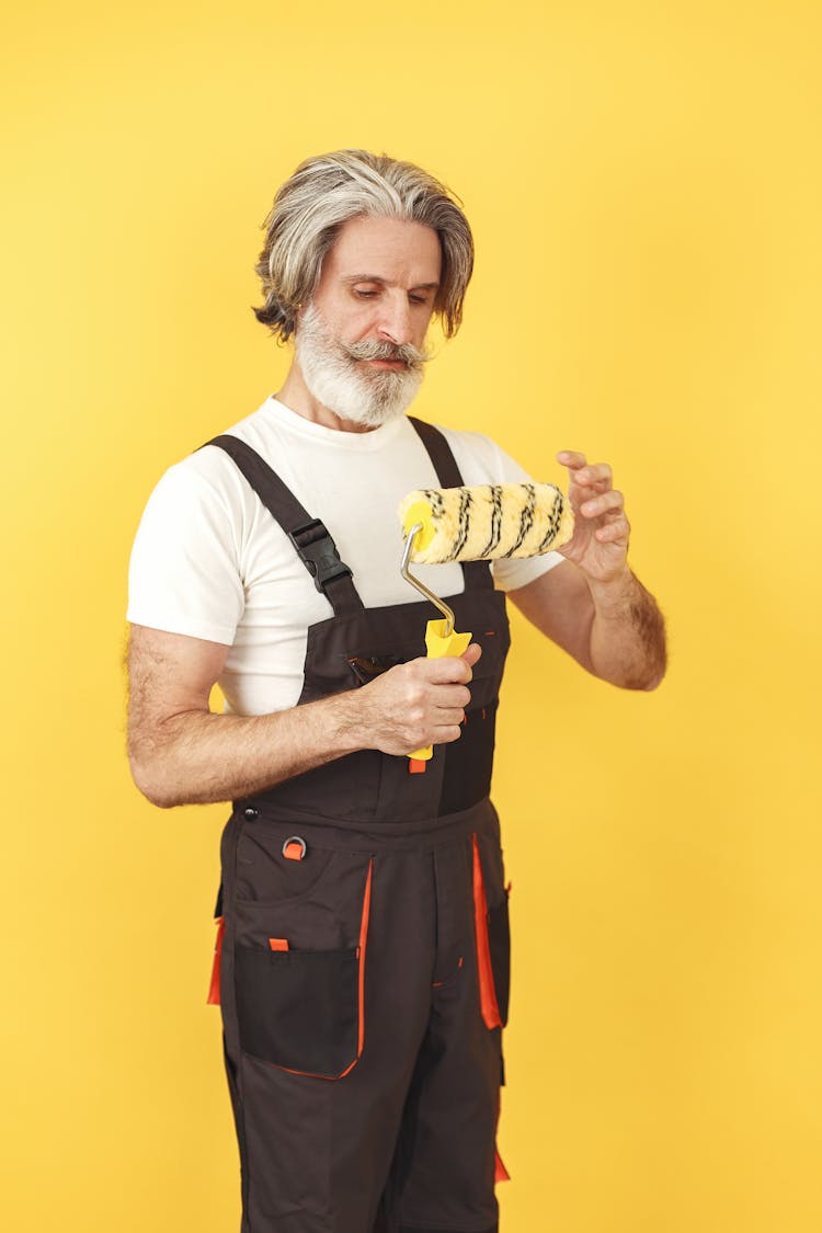 Elderly Man Holding A Paint Roller