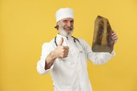 Man in White Chef Uniform Holding Brown Paper