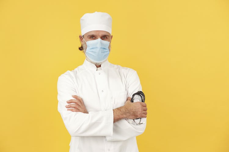 A Doctor Holding Stethoscope While His Arms Crossed