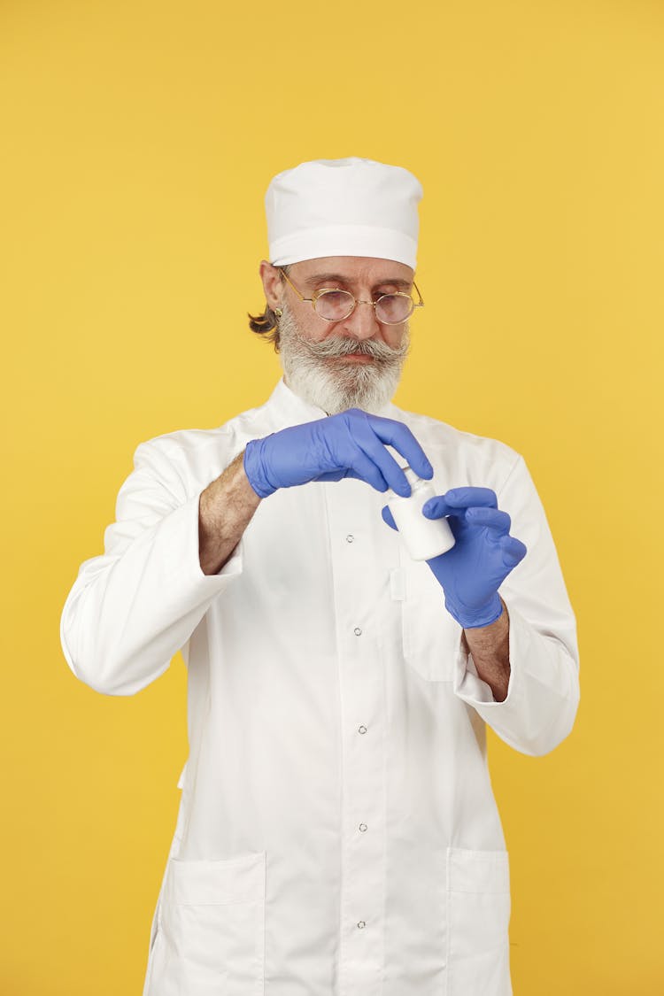 A Doctor Twisting The Medicine Bottle Lid 