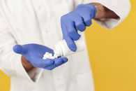 Person Holding Blue and White Plastic Bottle