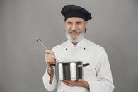 A Chef Holding a Cooking Pot and a Ladle
