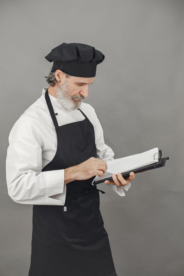 Professional chef reviewing food safety records on a clipboard