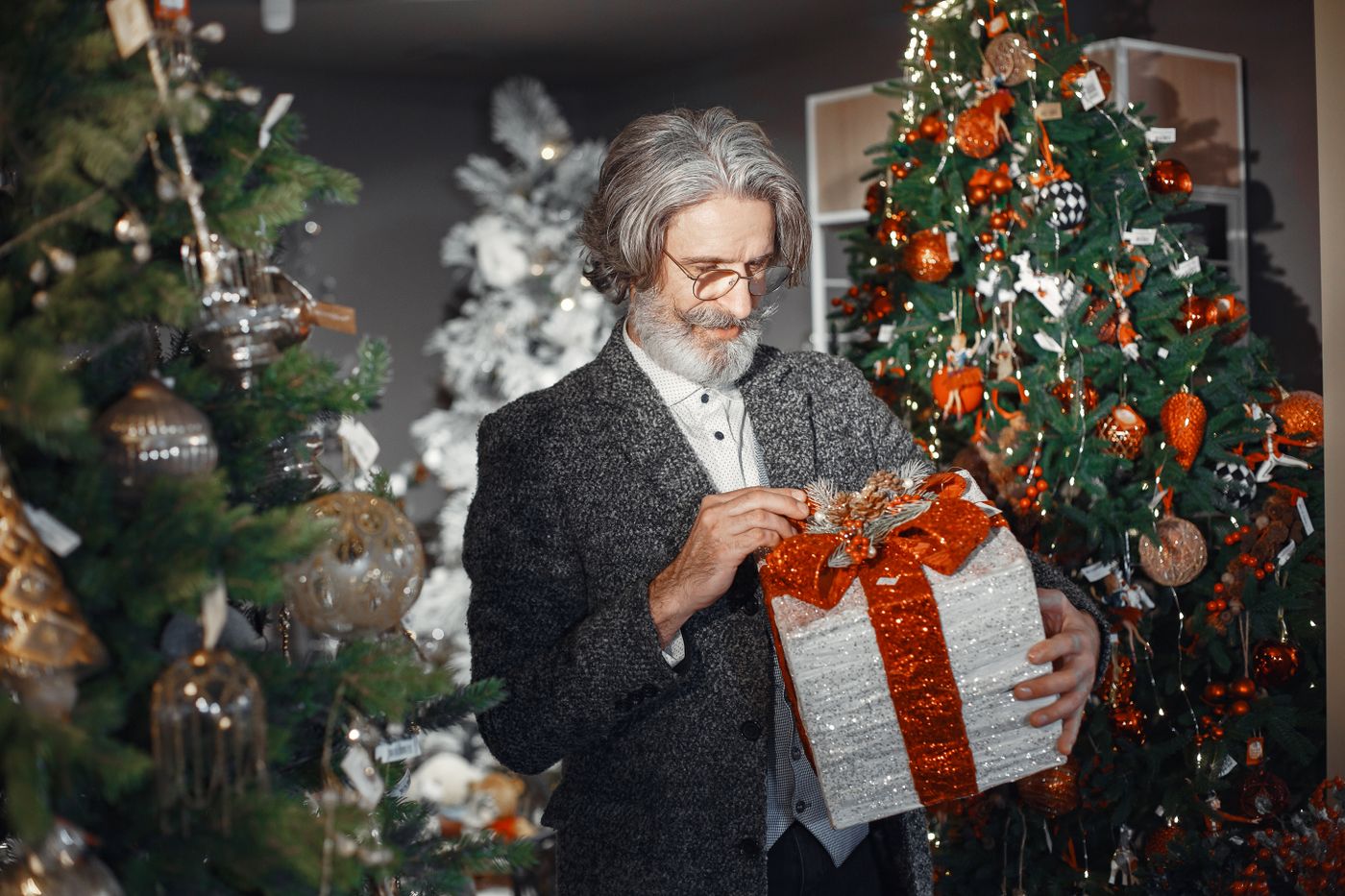 Homme aux cheveux gris tenant un cadeau emballé
