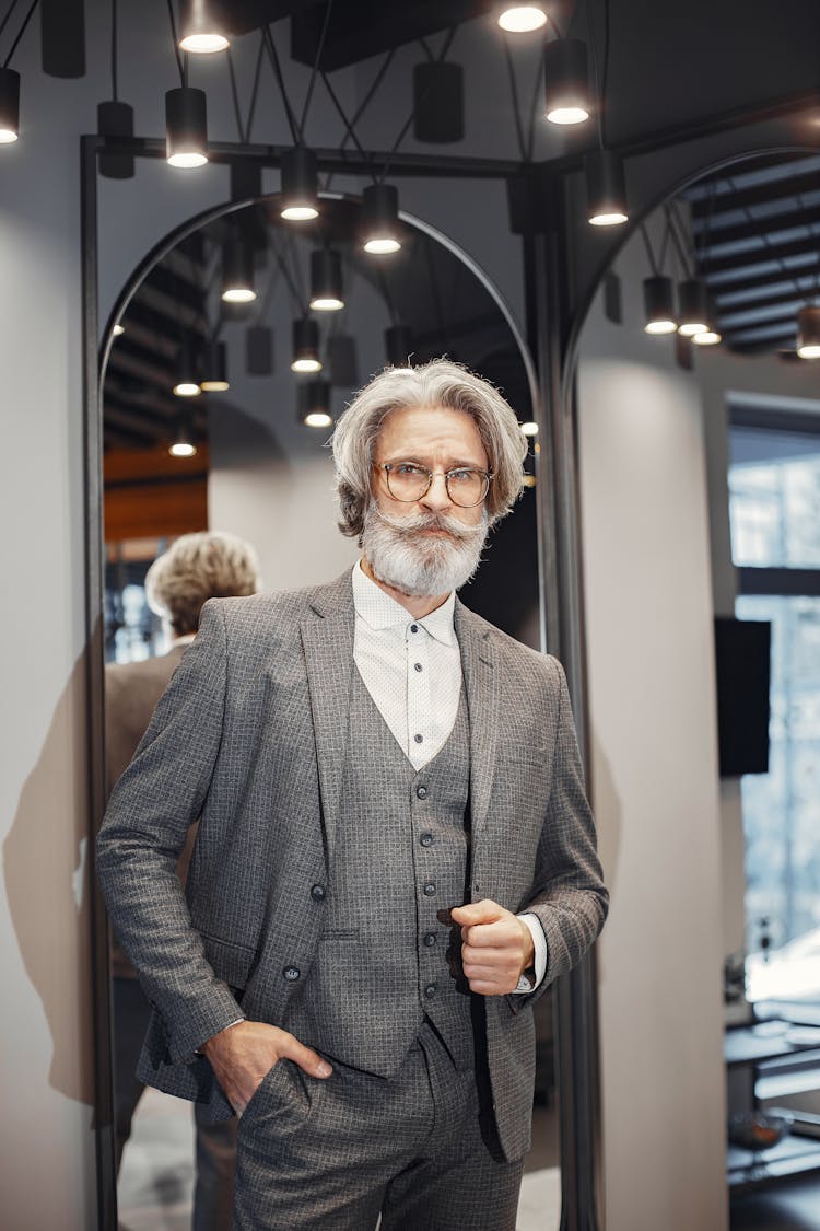 Man In Gray Suit Standing Near The Arch Mirror 