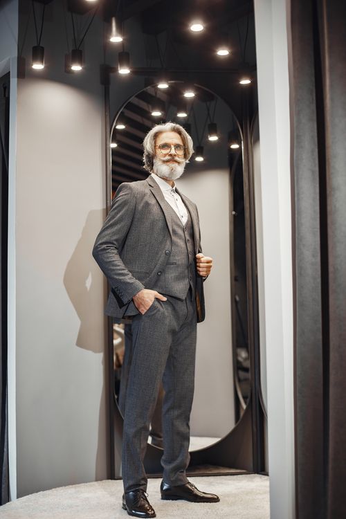 Free Sophisticated adult man with beard and eyeglasses in formal attire posing elegantly indoors. Stock Photo