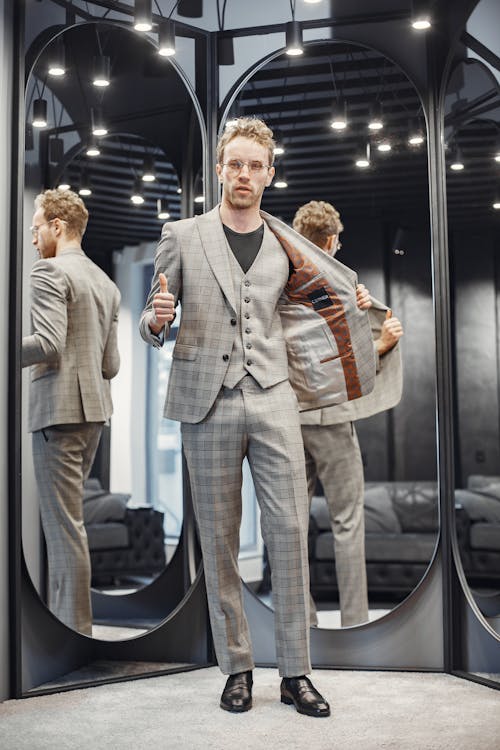Free Man in Gray Suit Standing Beside the Mirrors Stock Photo