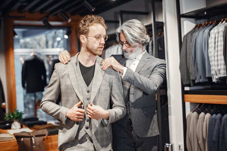 Bearded Man Fixing The Person's Suit Label