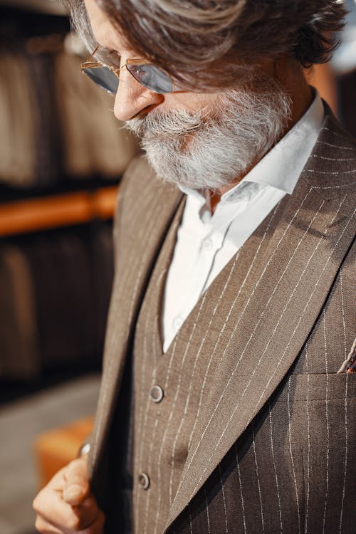 Close-Up Photo of an Elderly Man Fitting a Black Suit