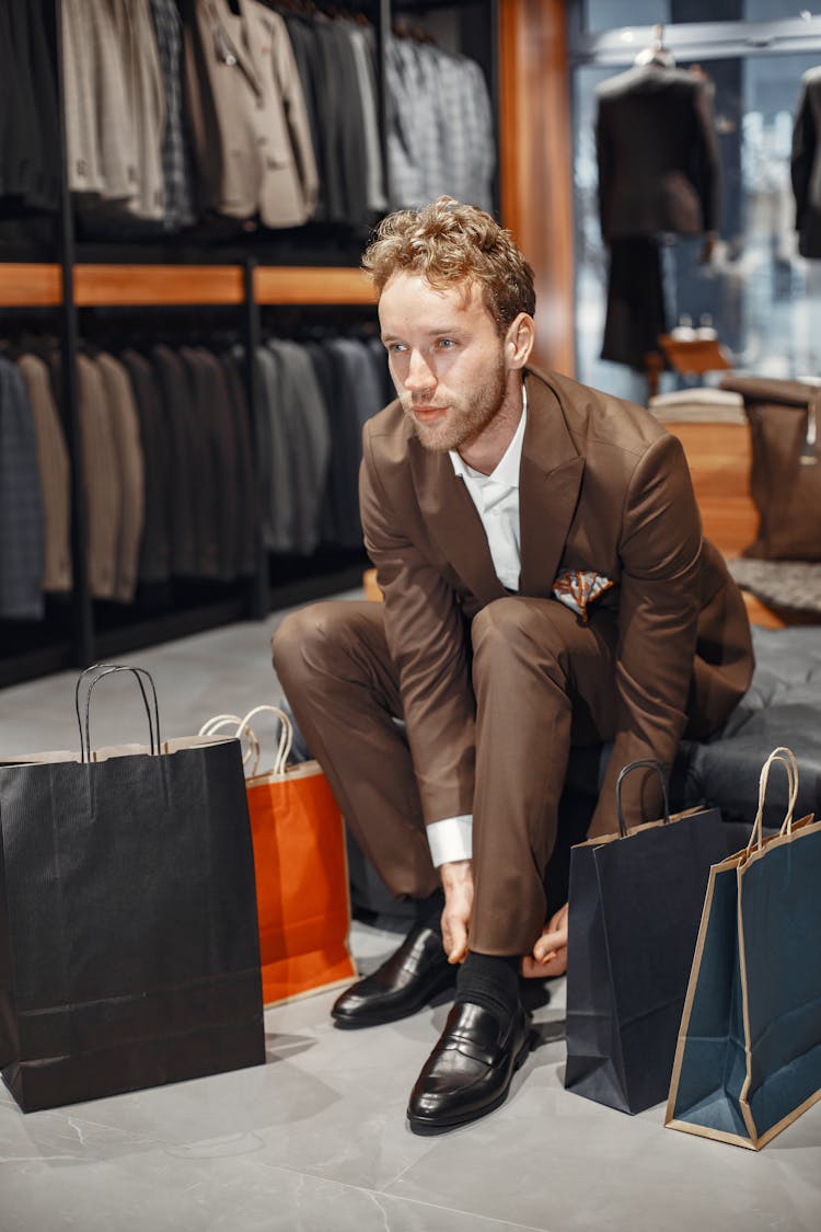 Man In Brown Suit Sitting Leather Ottoman