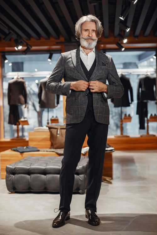 Free Stylish senior man in a suit, browsing in a modern clothing store. Stock Photo
