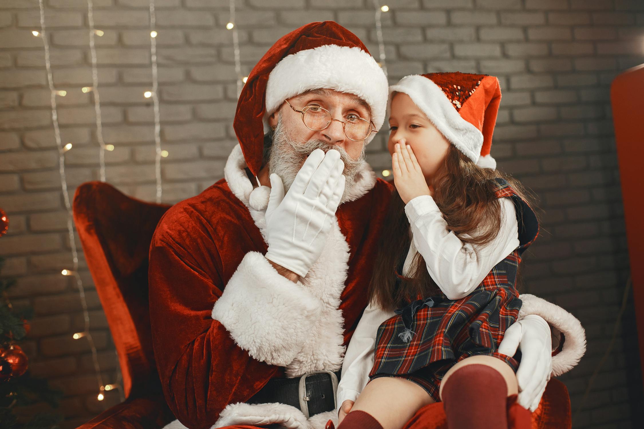 Little Girl Whispering into Santa Ear · Free Stock Photo