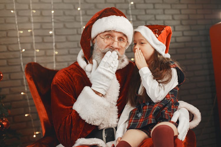 Little Girl Whispering Into Santa Ear