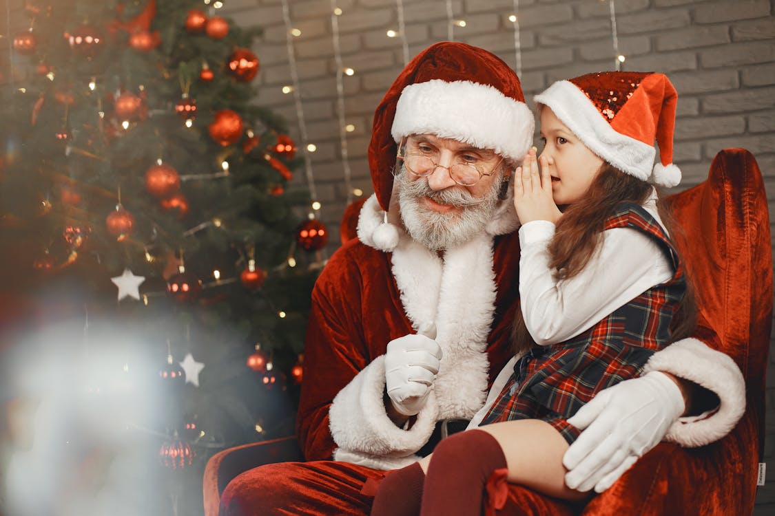 Free Little Girl Whispering into Santa Clauses Ear  Stock Photo