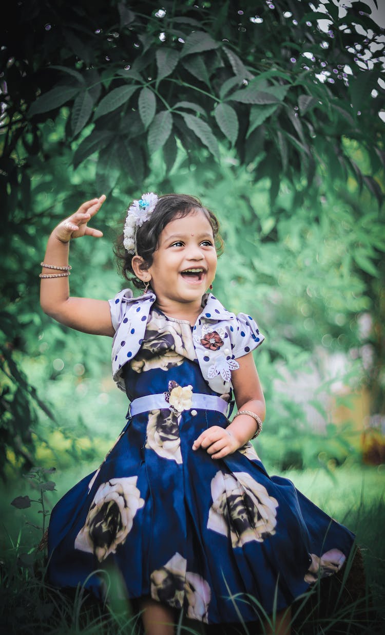 Little Girl In Navy Blue Dress Dancing Outdoors