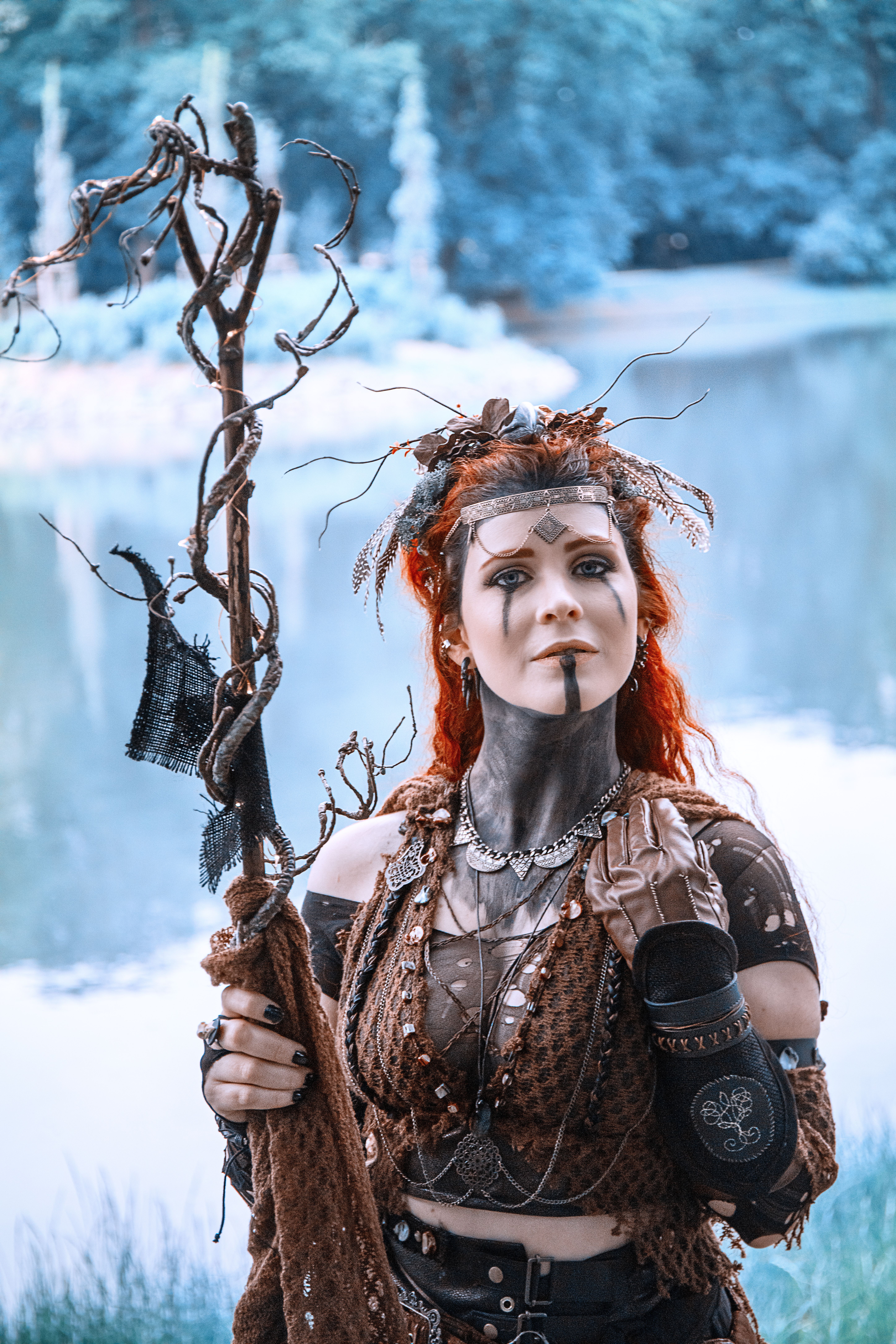 Steampunk cosplayer with mystical staff by a serene lake in Leipzig, Germany.