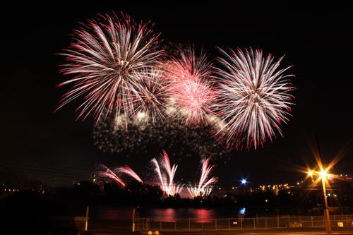 Free Vibrant fireworks burst over city lights, capturing a stunning display of celebration and color. Stock Photo